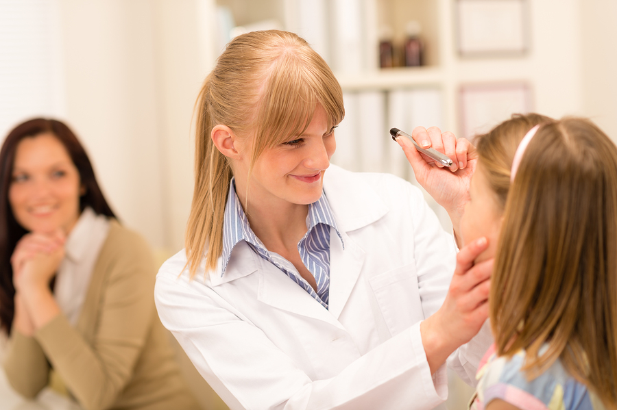 female optometrist giving a child an eye exam